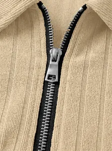 Close-up detail showing the silver metal zipper and ribbed fabric texture on knit polo shirt