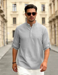 Detail view of a men's grey waffle knit Henley shirt with long sleeves rolled up outdoors