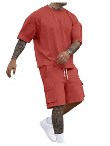 Close-up of men's summer two-piece set in terracotta red with oversized tee and cargo shorts.