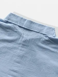 Close-up detail of the breathable linen texture and collar on a light blue men's shirt