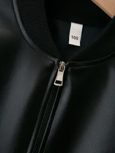 Close-up detail of smooth black PU leather jacket with silver zipper and ribbed collar