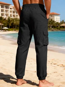 Rear view of lightweight black linen cargo pants for men on a sunny beach background