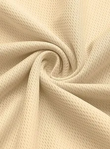 Macro view of beige breathable quick-dry mesh fabric for athletic performance wear