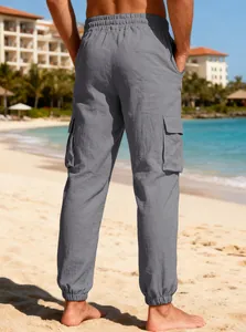 Detailed back view of men's lightweight grey linen cargo joggers on a tropical beach