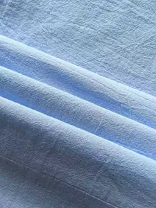 Macro detail showing the breathable light blue linen fabric texture for men's casual shirt