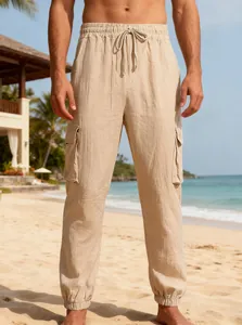 Close-up of lightweight linen cargo pants with drawstring and elastic cuffs on a beach