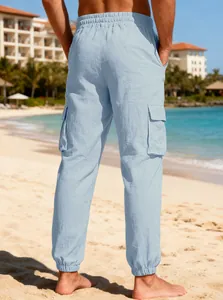 Back view of men's light blue linen cargo pants on a beach setting with pockets