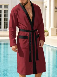 Detailansicht eines bordeauxroten Herren-Bademantels mit schwarzem Besatz am Pool.