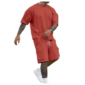 Men's summer two-piece sportswear set with oversized terracotta T-shirt and cargo shorts.