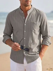 Casual men's grey striped linen long sleeve shirt with stand collar worn on a sunny beach