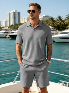 Stylish men's summer grey ribbed knit polo shirt and shorts casual set shown on a luxury yacht