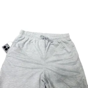 Detail of men's grey athletic sweatpants showing the elastic drawstring waist and pocket.