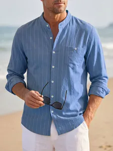 Men's light blue striped linen shirt with stand collar and long sleeves in a beach setting