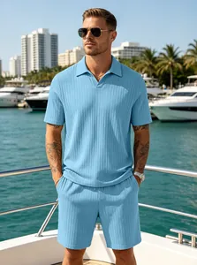 Detail view of men's blue ribbed knit polo shirt and shorts set on a yacht.