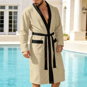 Elegant men's long jacquard beige bathrobe with black trim and belt by a sunny pool