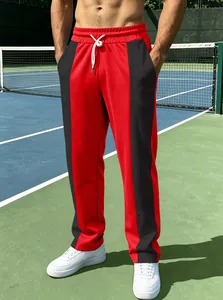 Nahaufnahme einer rot-schwarzen Herren-Sporthose mit Farbblock-Design auf Tennisplatz