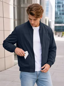 Close-up detail of navy blue bomber jacket showing functional side pocket on male model