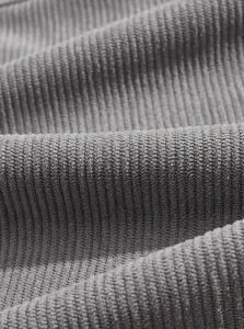 Macro detail of high-quality gray corduroy fabric showing soft vertical ribbed texture
