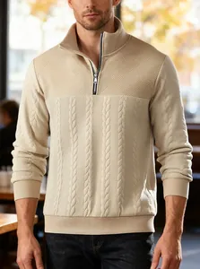 Detalle del patrón de patchwork de punto grueso y cremallera metálica en el suéter beige de hombre