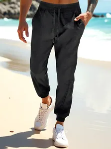 Comfortable men's black joggers featuring elastic waist and cuffs, modeled on a beach