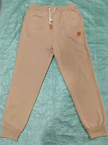 Full layout of khaki men's drawstring sports jogger pants with a small leather label detail