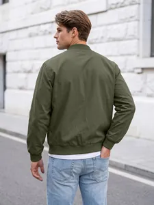 Detailed back view of a men's olive green minimalist bomber jacket in an outdoor setting.