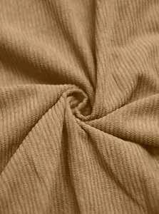 Close-up of camel brown heavy corduroy fabric texture showing ribbed pattern.