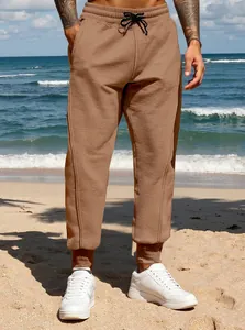 Close-up view of men's brown joggers featuring drawstring waist and elastic cuffs.