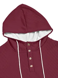Detailansicht eines burgunderroten Jacquard-Hoodies mit Knopfkragen und weißen Kordelzügen