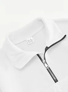 Dettaglio di un maglione da uomo in maglia jacquard bianca con mezza zip e trama fine