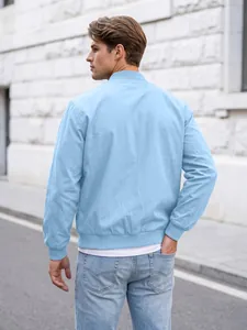 Back view of a man wearing a light blue solid color bomber jacket in an outdoor street setting