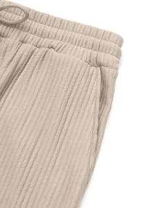 Close-up of ribbed fabric texture on men's casual high-waisted beige pants.