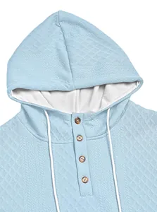 Nahaufnahme eines hellblauen Herren-Hoodies mit Jacquard-Textur und Knopf-Hals-Detail.