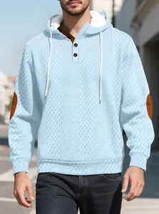 Detailansicht hellblauer Jacquard-Hoodie mit braunen Ellbogen-Patches und Knopfkragen