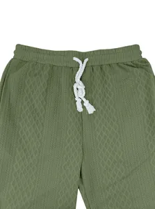 Dettaglio ravvicinato dei pantaloni sportivi jacquard verde oliva da uomo con cordino