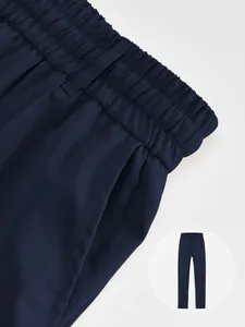 Close-up of navy blue men's jogger pants showing elastic waistband and twill fabric