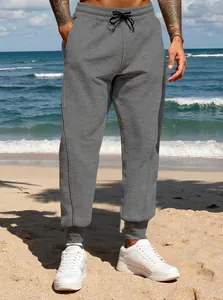 Detail of men's grey casual joggers with elastic drawstring waist and ribbed cuffs.