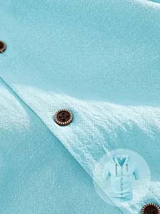Detail of light blue textured fabric on men's short sleeve hooded casual shirt
