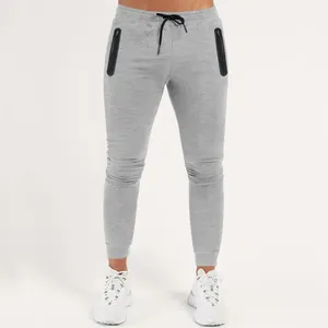 Grey slim-fit men's sports joggers featuring black zippered pockets and an adjustable drawstring waist