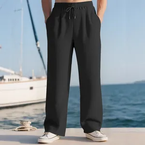 Men's black vertical ribbed casual wide-leg trousers with drawstring waist on a dock.