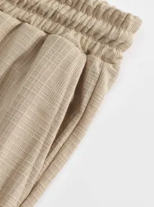 Detailed macro view of the elastic waistband and side pocket on beige ribbed cargo pants