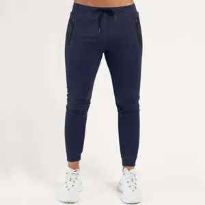 Close-up detail of navy blue men's athletic joggers with zip pockets and ribbed cuffs