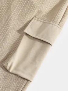 Close-up detail of textured khaki men's cargo pants showing functional pocket and flap