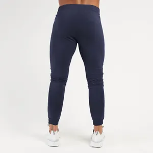 Back view of slim-fit men's navy blue athletic joggers with elastic tapered cuffs