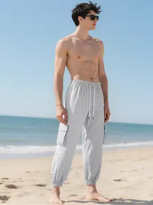 Light gray men's cargo joggers featuring tapered cuffs and multi-pockets on beach