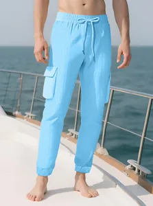 Light blue men's cargo jogger pants with drawstring and side flap pocket on a yacht.