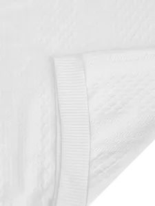 Macro detail of white textured jacquard fabric and ribbed cuff on men's hoodie garment