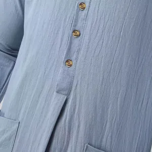Gros plan d'une robe pour homme en lin avec boutons marrons et un col montant élégant.
