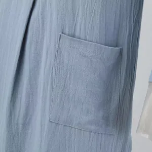 Détail de la poche et du tissu texturé sur une robe longue pour homme de style ethnique