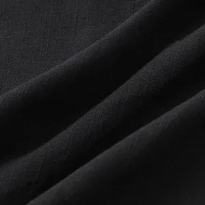 Nahaufnahme von hochwertigem schwarzem, atmungsaktivem Baumwollstoff mit feiner Textur.